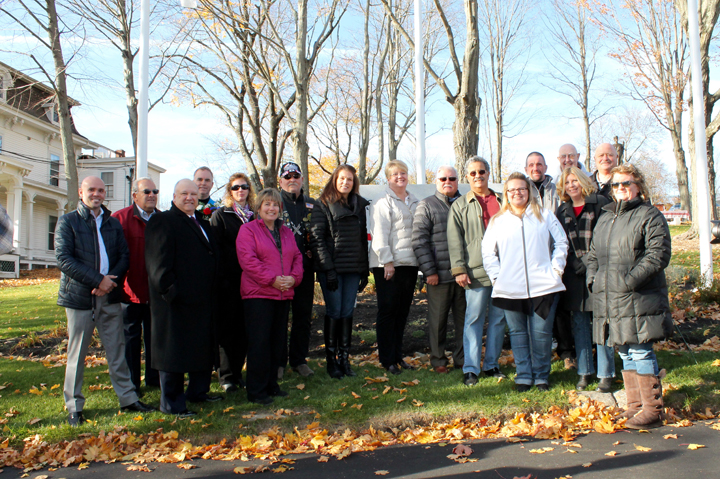Exchange Club members pose in front of the new Isaac L. Prouty Memorial Park sign.